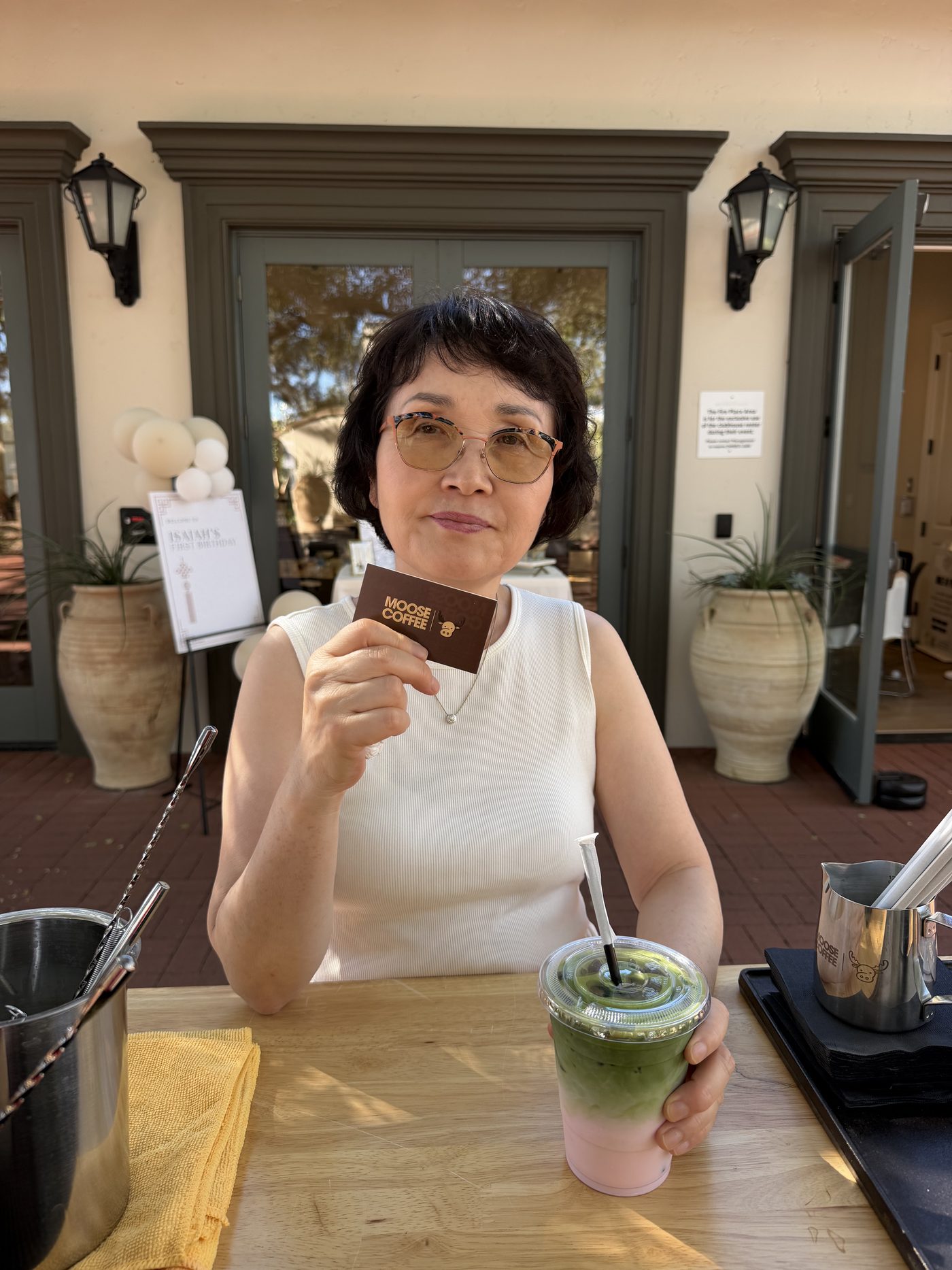 A guest holding a Moose Coffee card and an iced strawberry matcha