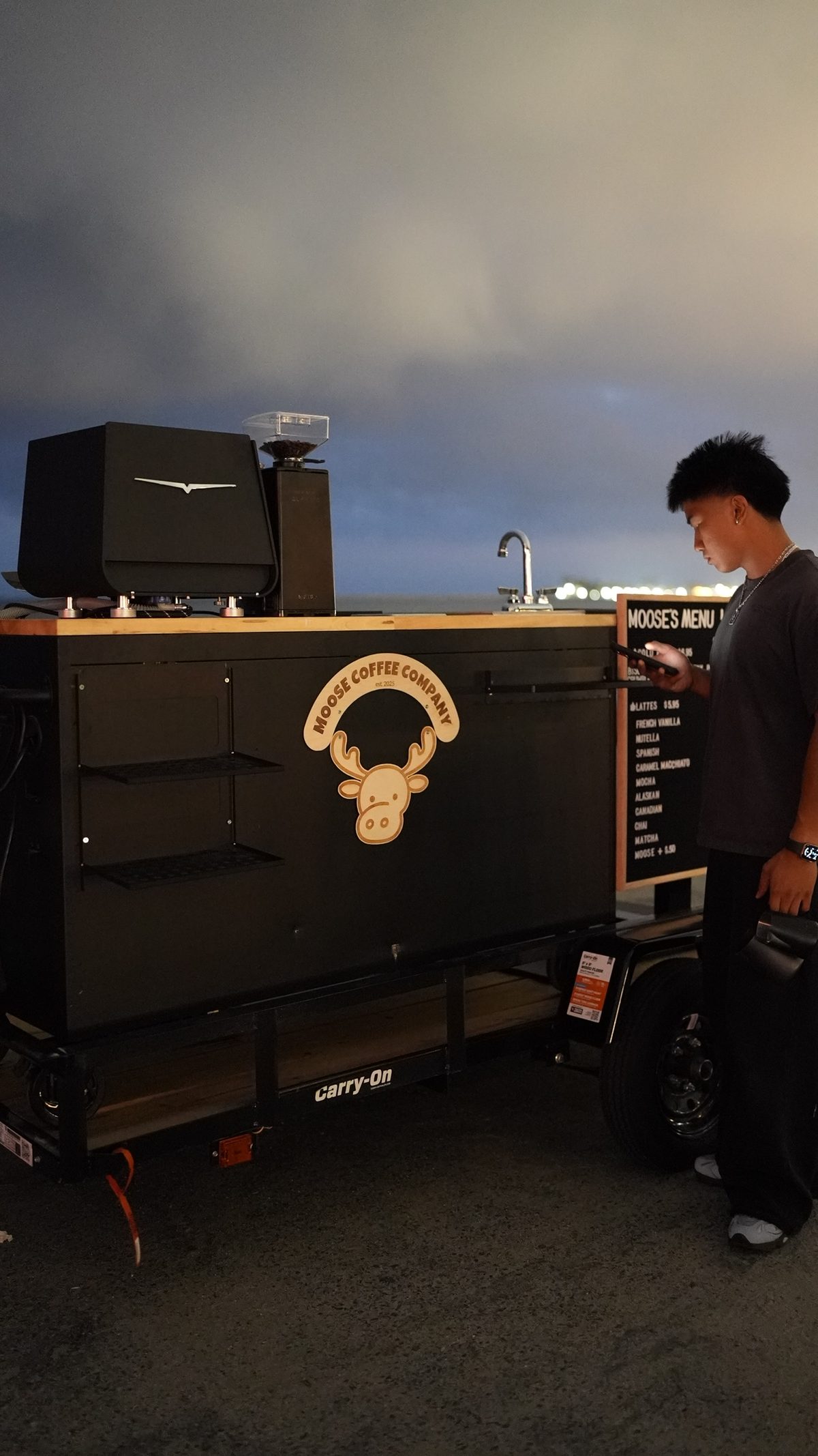 Moose Coffee barista serving from the mobile espresso cart at an evening event